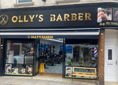 Exterior of Olly's Barber showcasing vibrant signage, located near Sean’s Chair in Sheerness, England, GB.