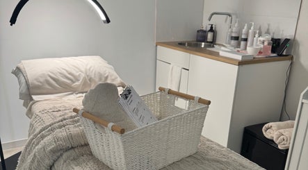 Relaxation space at The Derm Lounge, Woody Point, Queensland, AU, featuring cozy treatment bed and elegant decor.