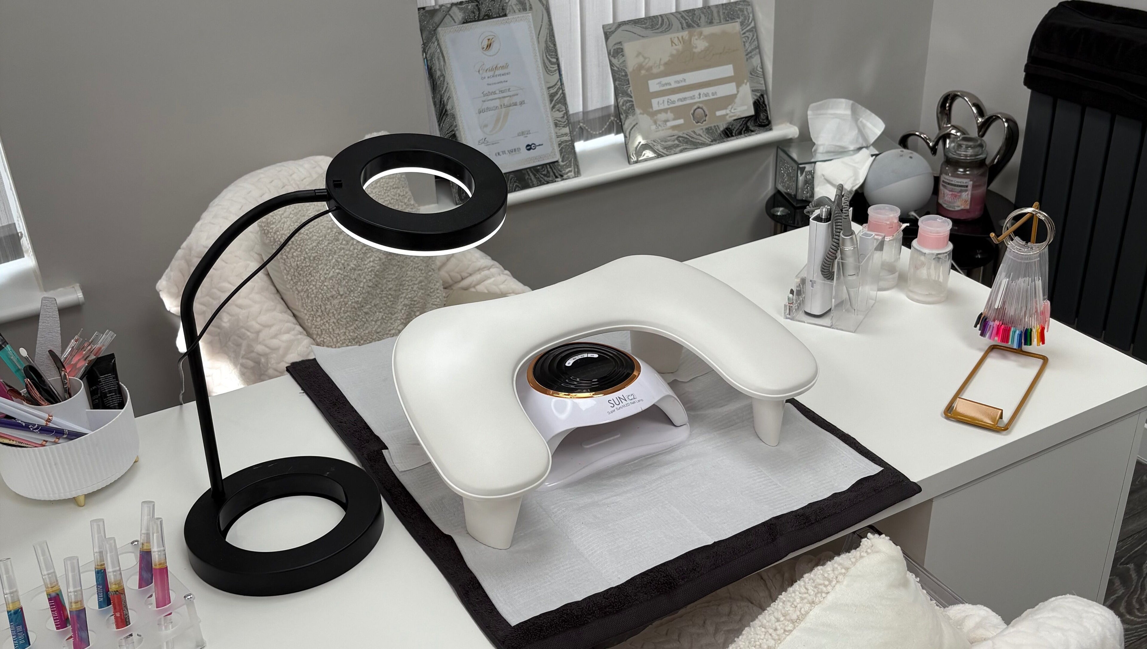 Nail station at TILLYnailedit, Chadderton, England with tools and UV lamp on a white desk.