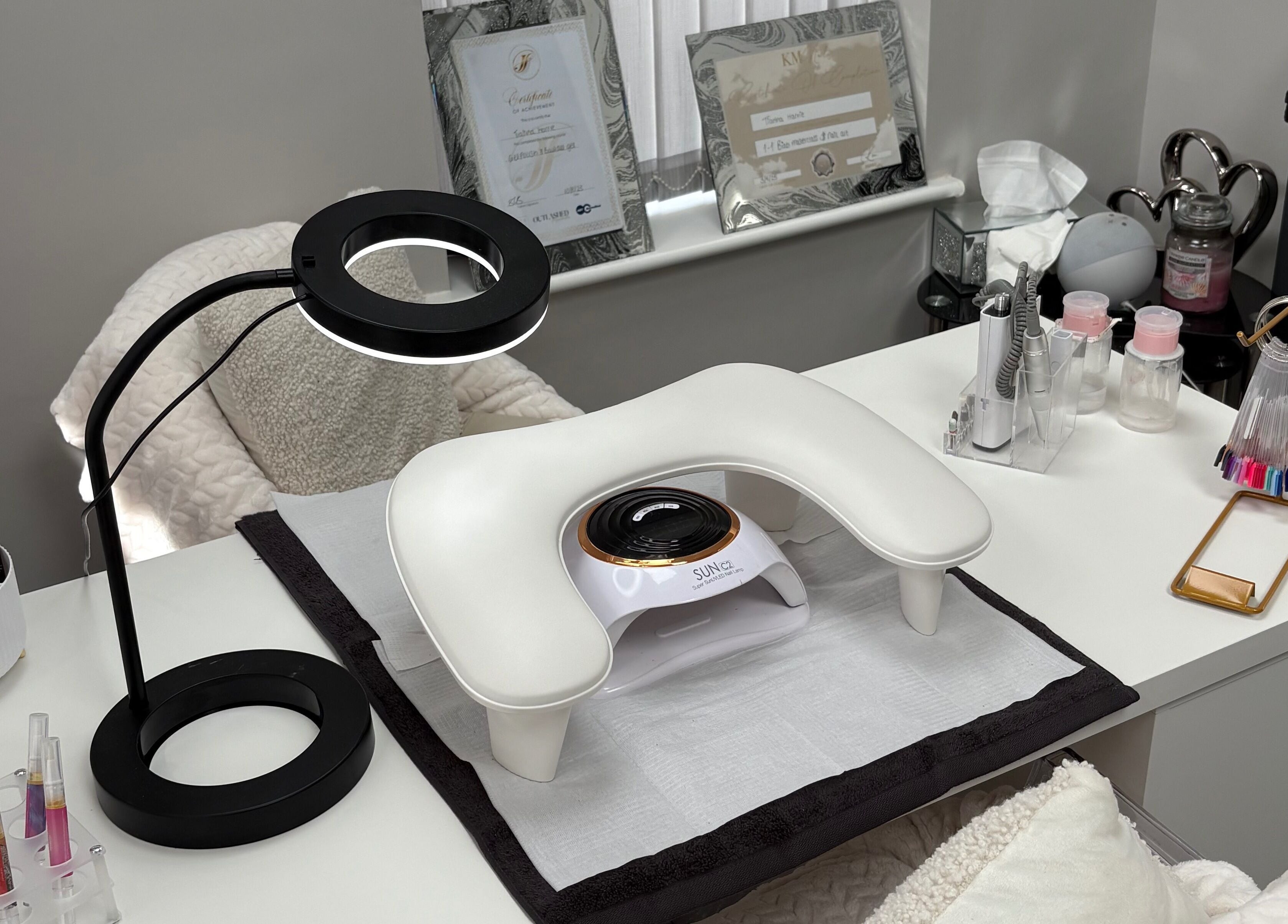 Nail station at TILLYnailedit, Chadderton, England with tools and UV lamp on a white desk.