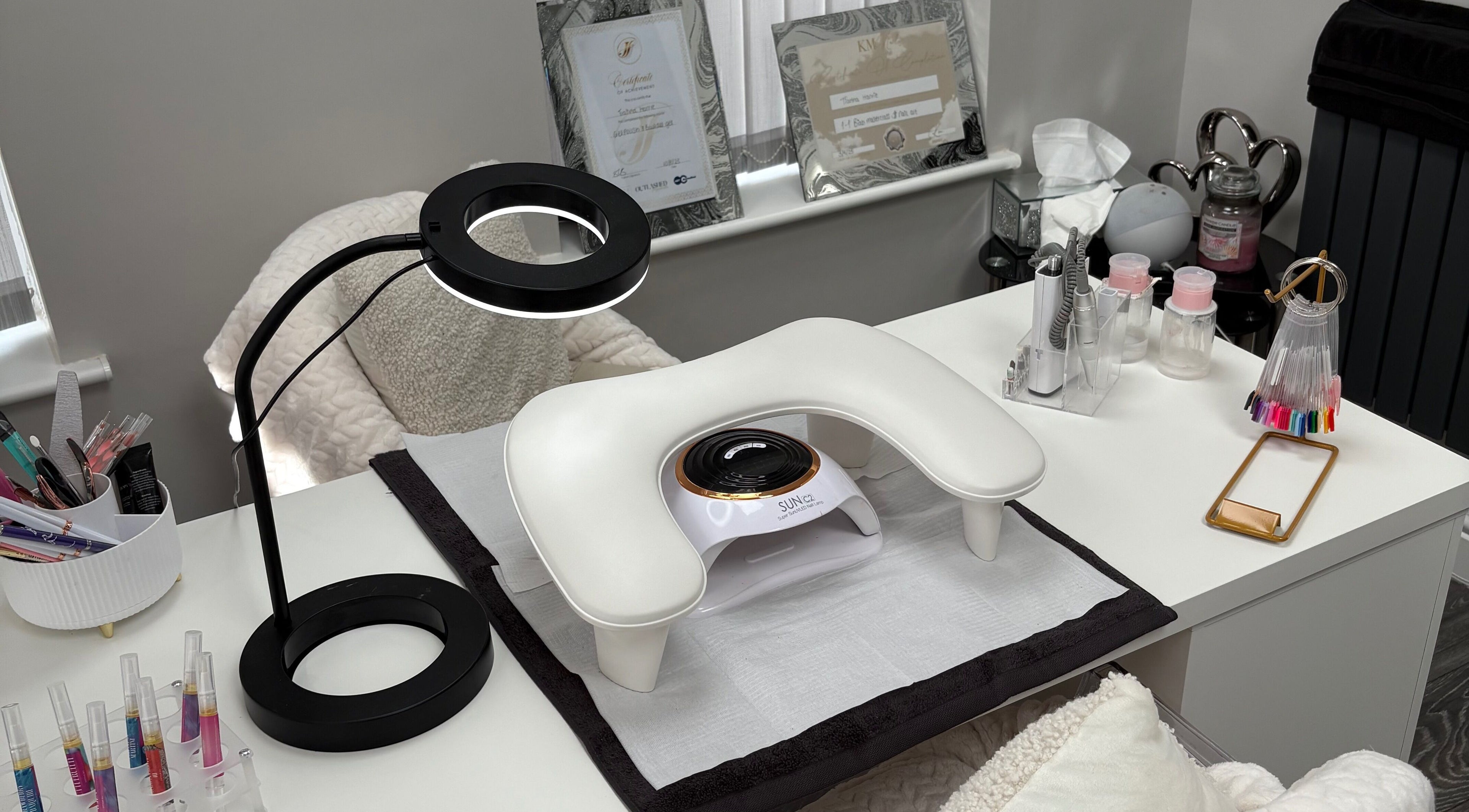 Nail station at TILLYnailedit, Chadderton, England with tools and UV lamp on a white desk.