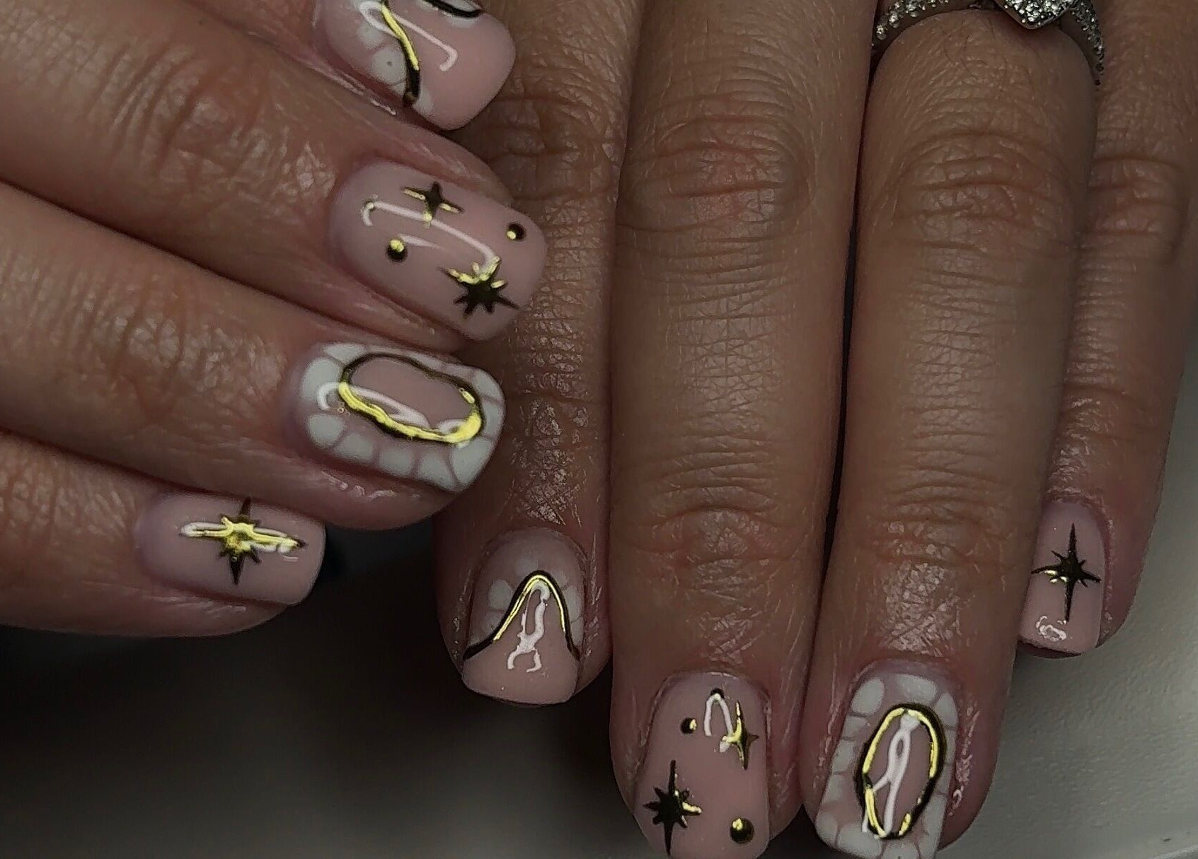 Elegant cosmic nail art design at TILLYnailedit, Chadderton, England, GB with stars and golden accents.