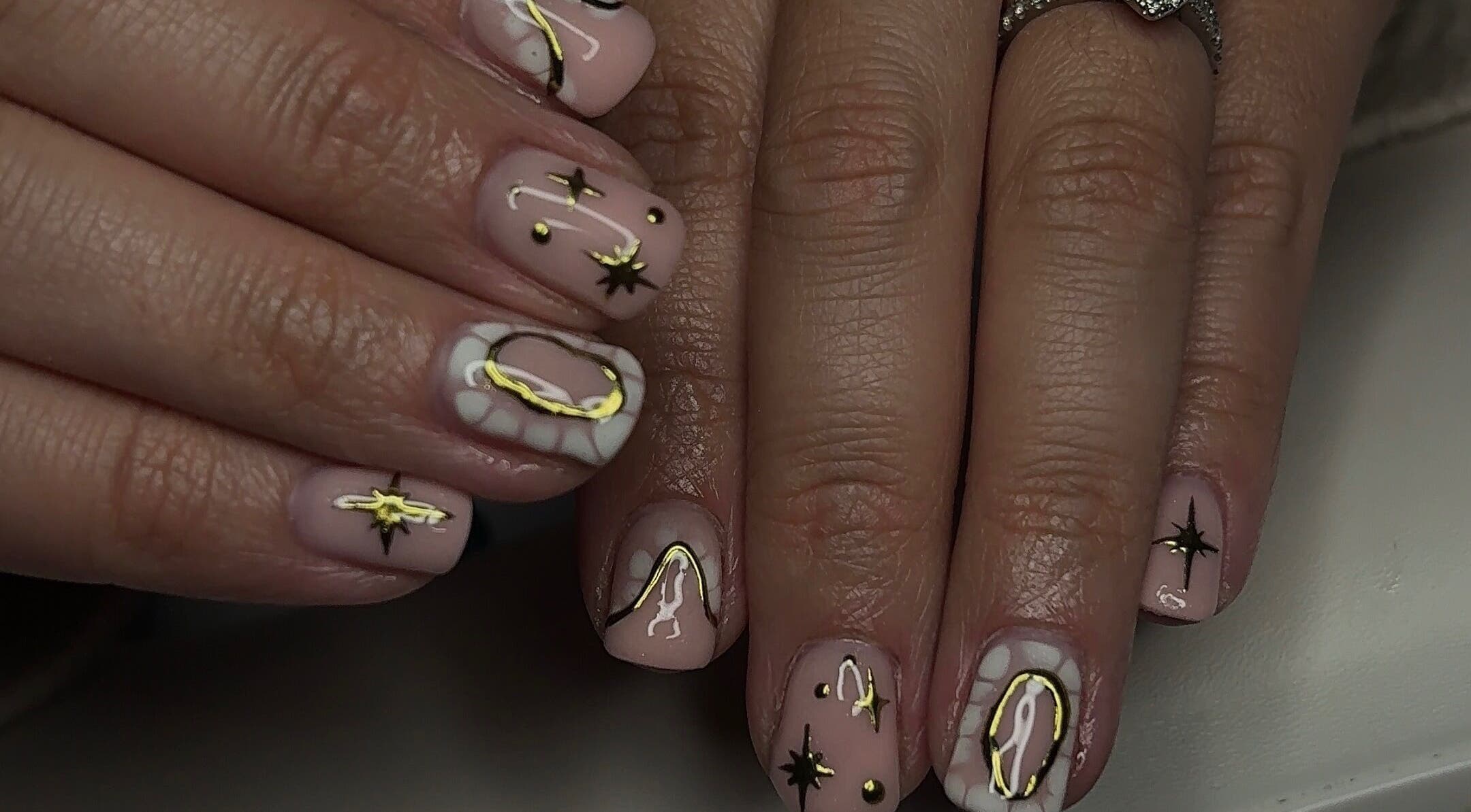 Elegant cosmic nail art design at TILLYnailedit, Chadderton, England, GB with stars and golden accents.