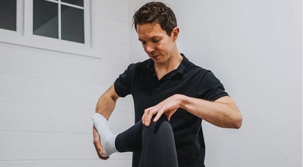 Therapist providing a leg stretch at NPC Sports Massage, Maidstone, England, GB.