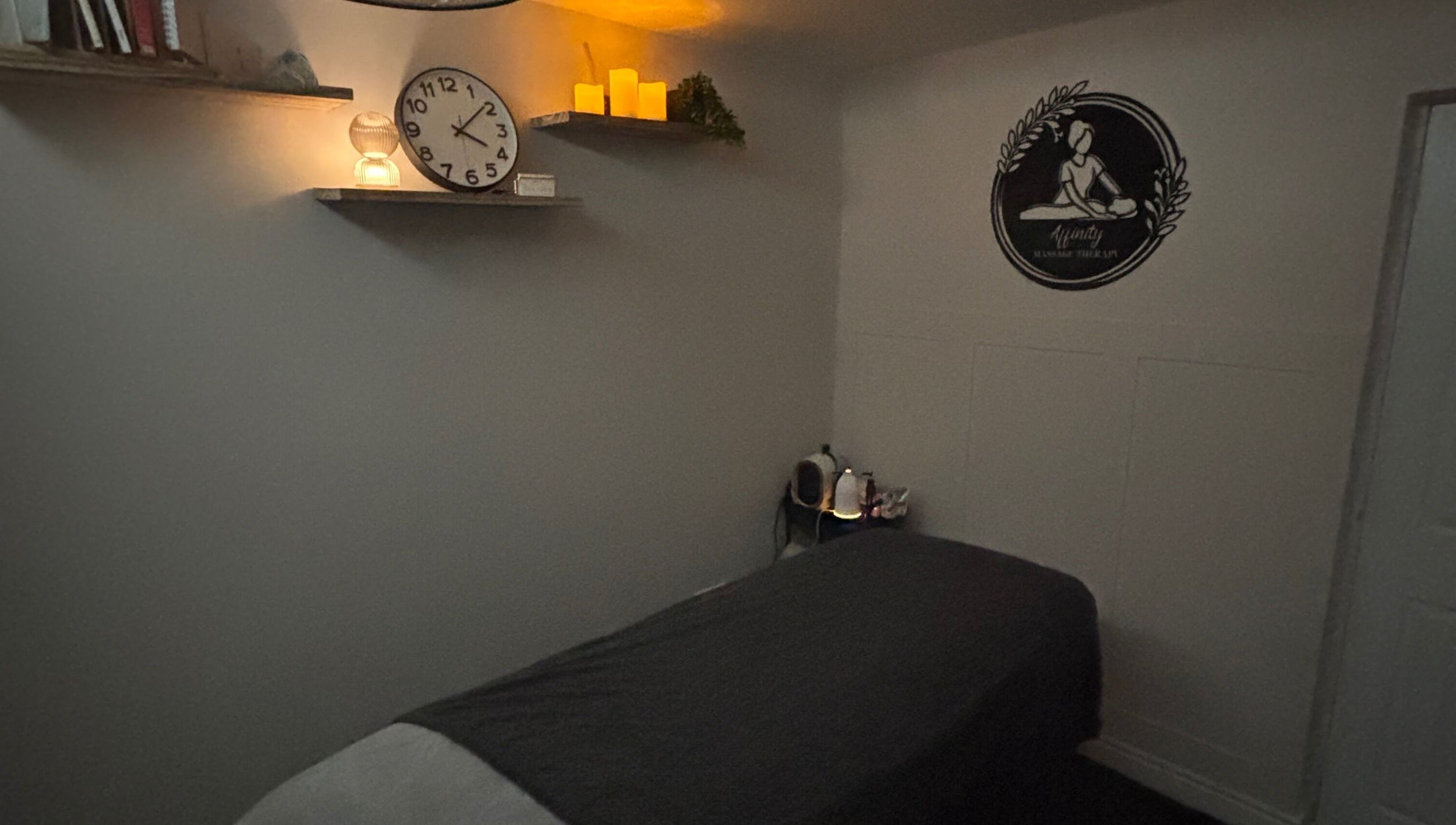 Cozy massage room at Affinity Massage, Leigh, England. Features dim lighting and a massage table.