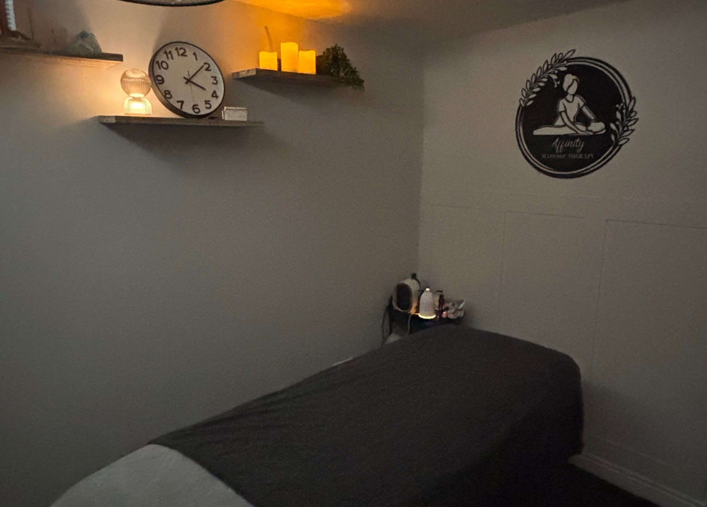 Cozy massage room at Affinity Massage, Leigh, England. Features dim lighting and a massage table.