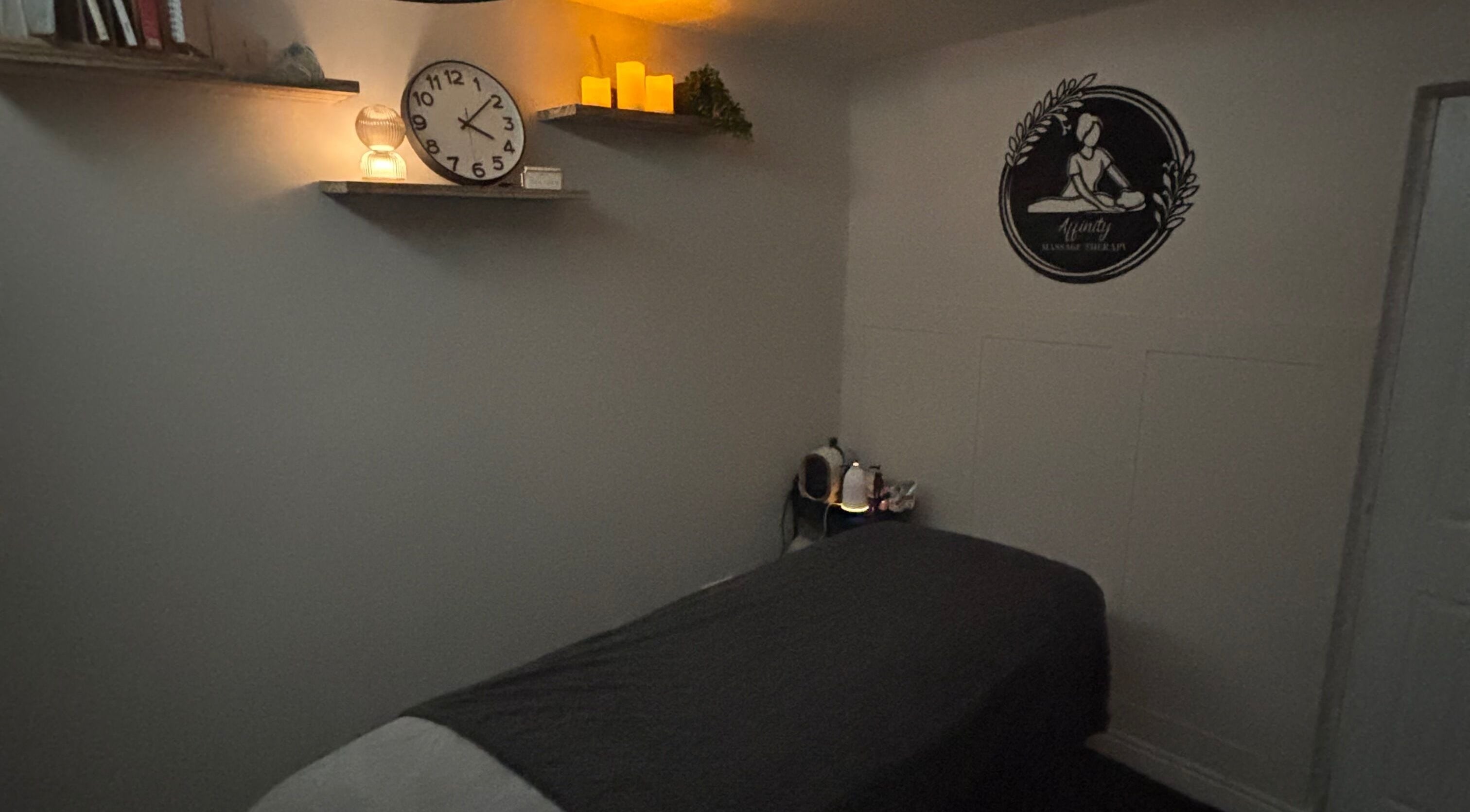 Cozy massage room at Affinity Massage, Leigh, England. Features dim lighting and a massage table.
