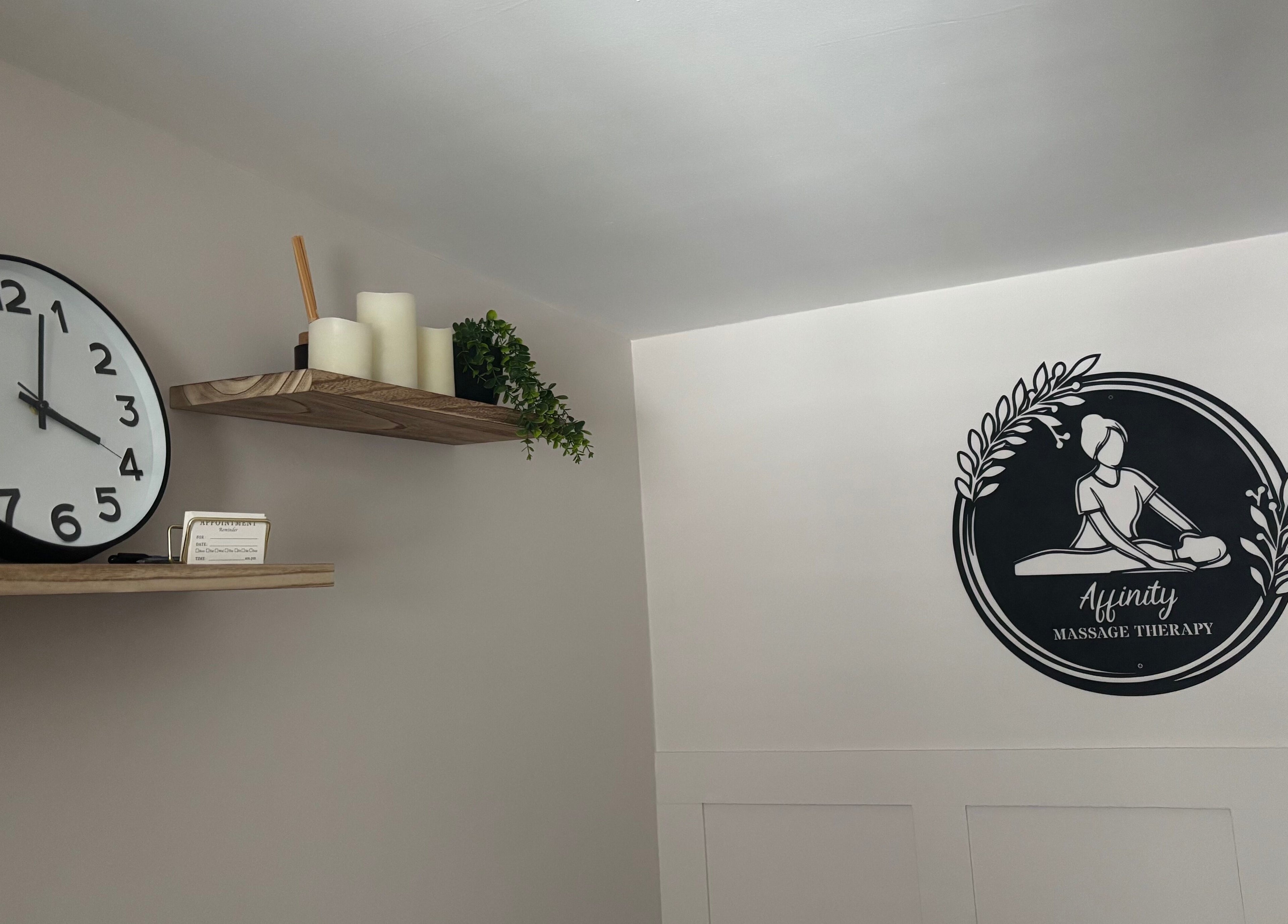 Elegant wall clock and Affinity Massage logo at Leigh, England, GB.