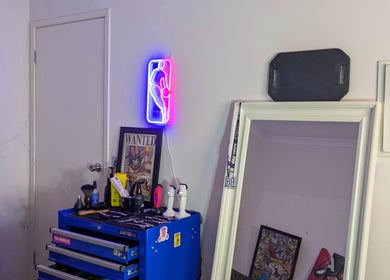 Cozy decor at Slim Fadey barbershop, Melbourne, Victoria, AU with neon light and mirror setting.