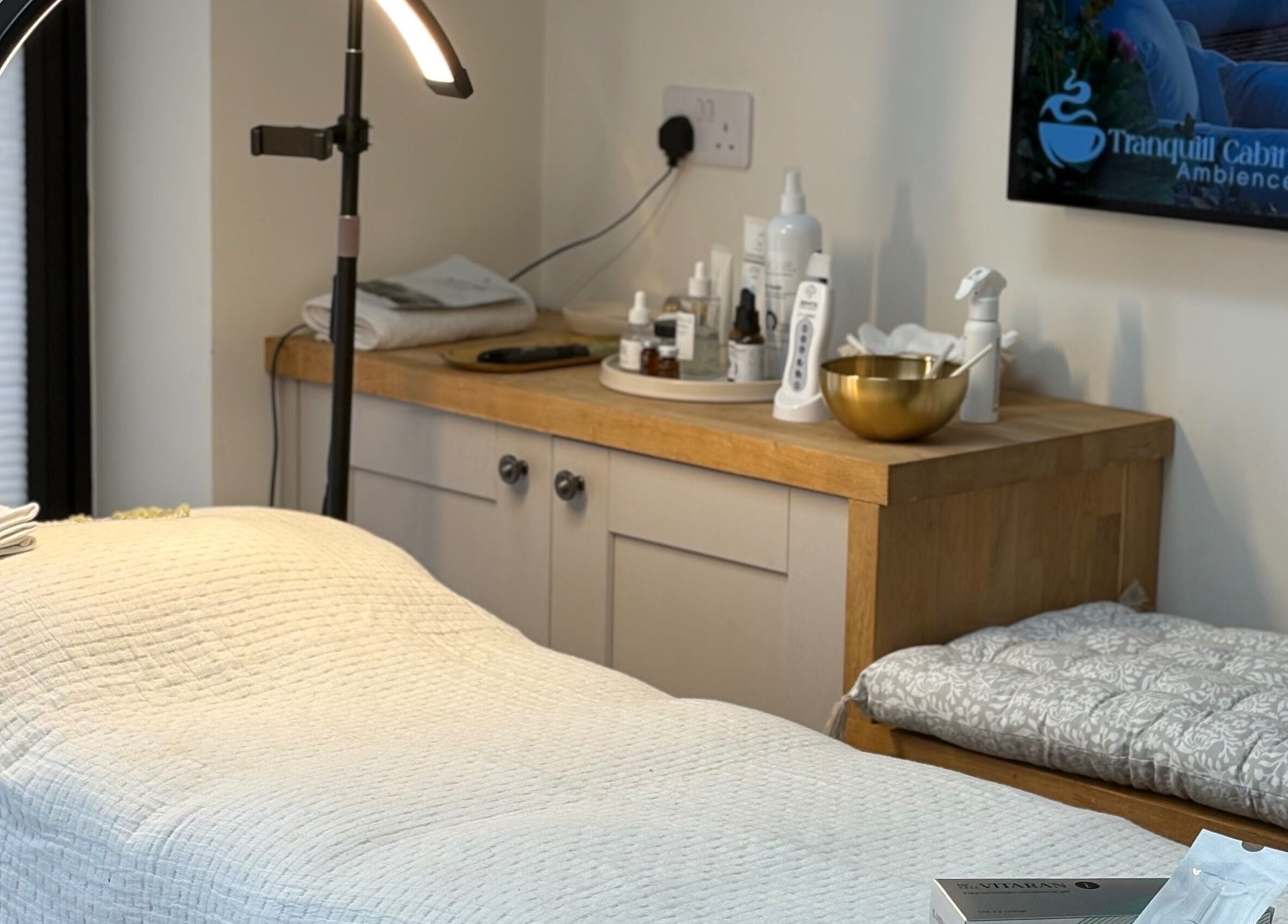 Calming treatment room at Glow by Mykala, Carlton, England, GB with cozy bed and luxury skincare products.