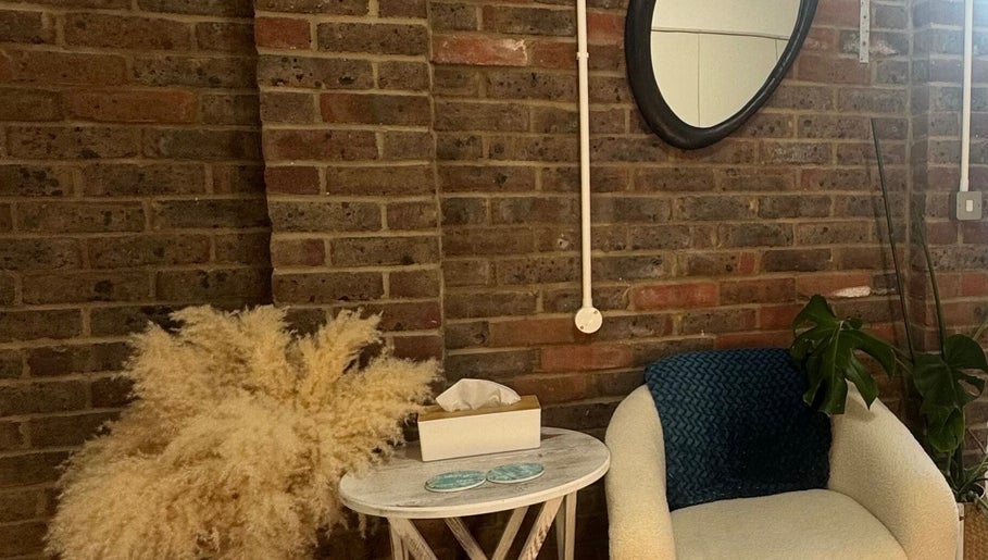 Cozy seating area at Gorgeous Gate Aesthetics in Burgess Hill, England, GB with stylish decor and brick wall.