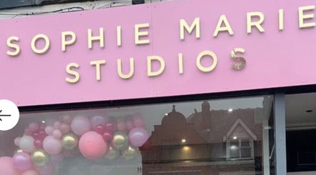 Hindle Luxx Aesthetics storefront in Manchester, England, with pink and gold balloon decor.