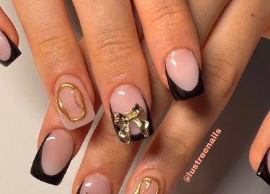 Chic black and gold nail art with bows at Lustrée Nails, Northampton, England, GB.
