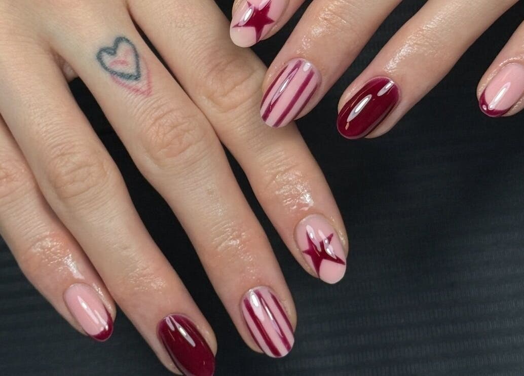 Elegant nail art design at Lustrée Nails, Northampton, England, GB showcasing red and pink patterns.