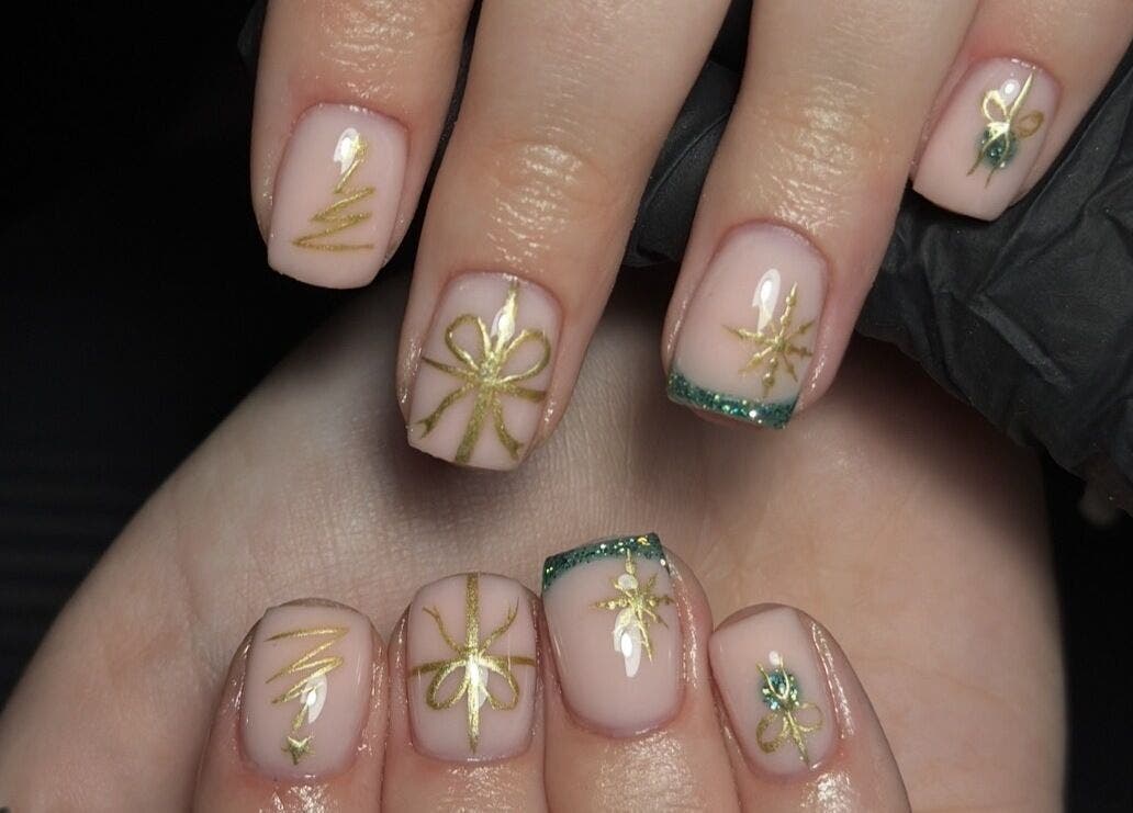 Elegant gold nail art at Lustrée Nails, Northampton, England, GB. Exquisite detail on manicured hands.