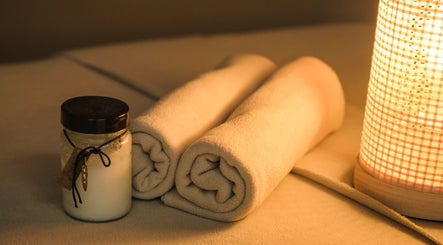 Relaxing ambiance at Essence Body & Soul Massage in Te Puke, Bay Of Plenty Region, NZ with candle and towels.