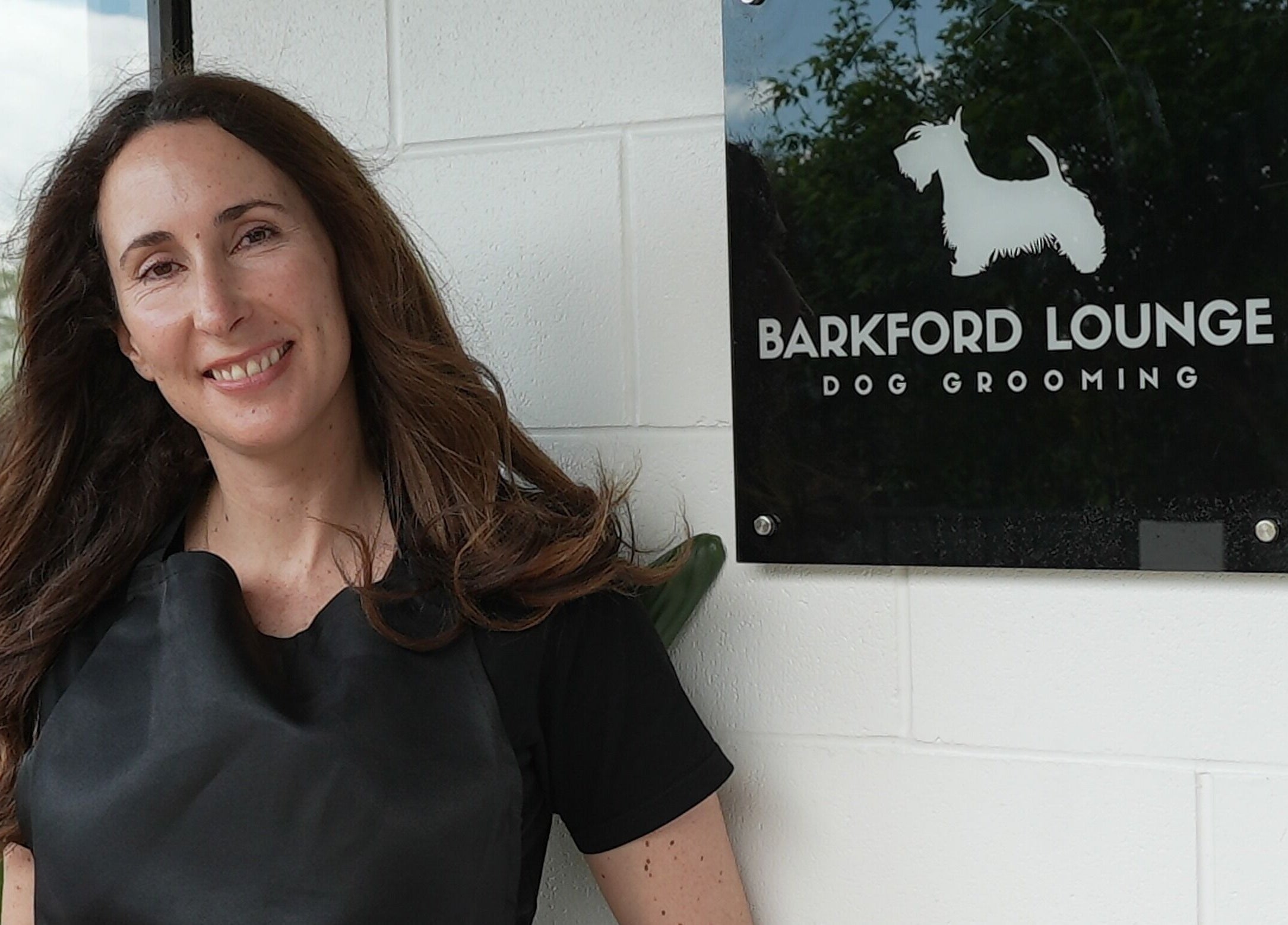 Smiling woman at Barkford Lounge entrance, Auckland, NZ.