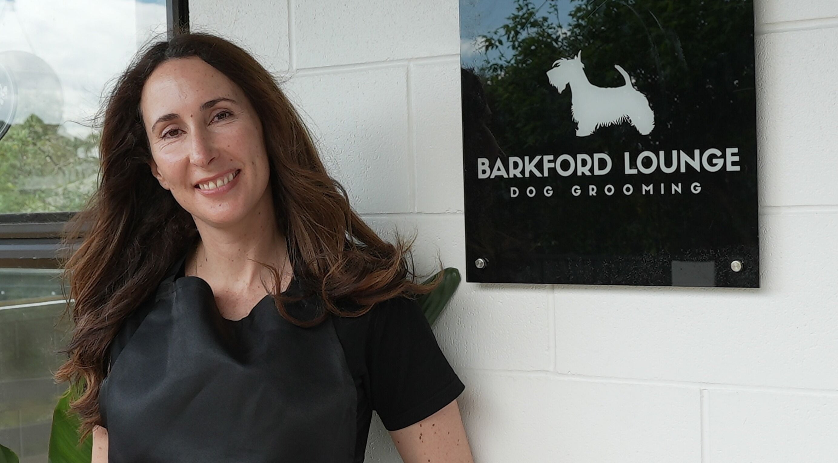 Smiling woman at Barkford Lounge entrance, Auckland, NZ.