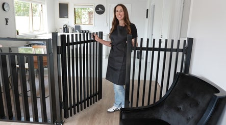 Staff at Barkford Lounge in Auckland, NZ welcomes visitors with a warm smile in a modern, cozy interior setting.