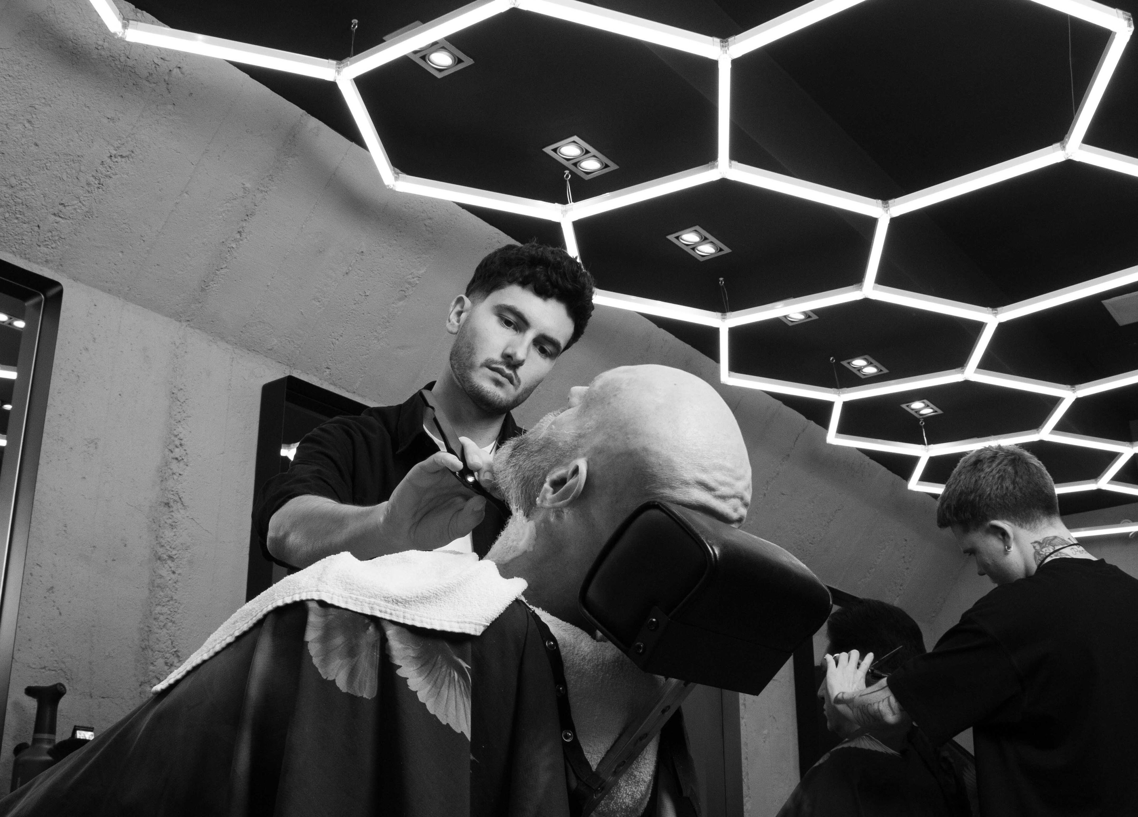 Barber at Gents & Rascals Barbershop - Britomart Store, Auckland, NZ, expertly styling a client's beard.