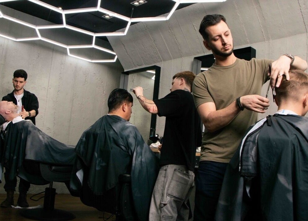 Stylish interior of Gents & Rascals Barbershop - Britomart Store in Auckland, Auckland, NZ with barbers at work.