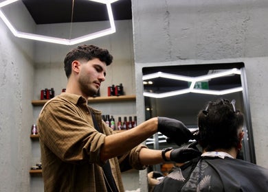 Barber styling hair at Gents & Rascals Barbershop - Britomart Store, Auckland, Auckland, NZ, under modern lighting.