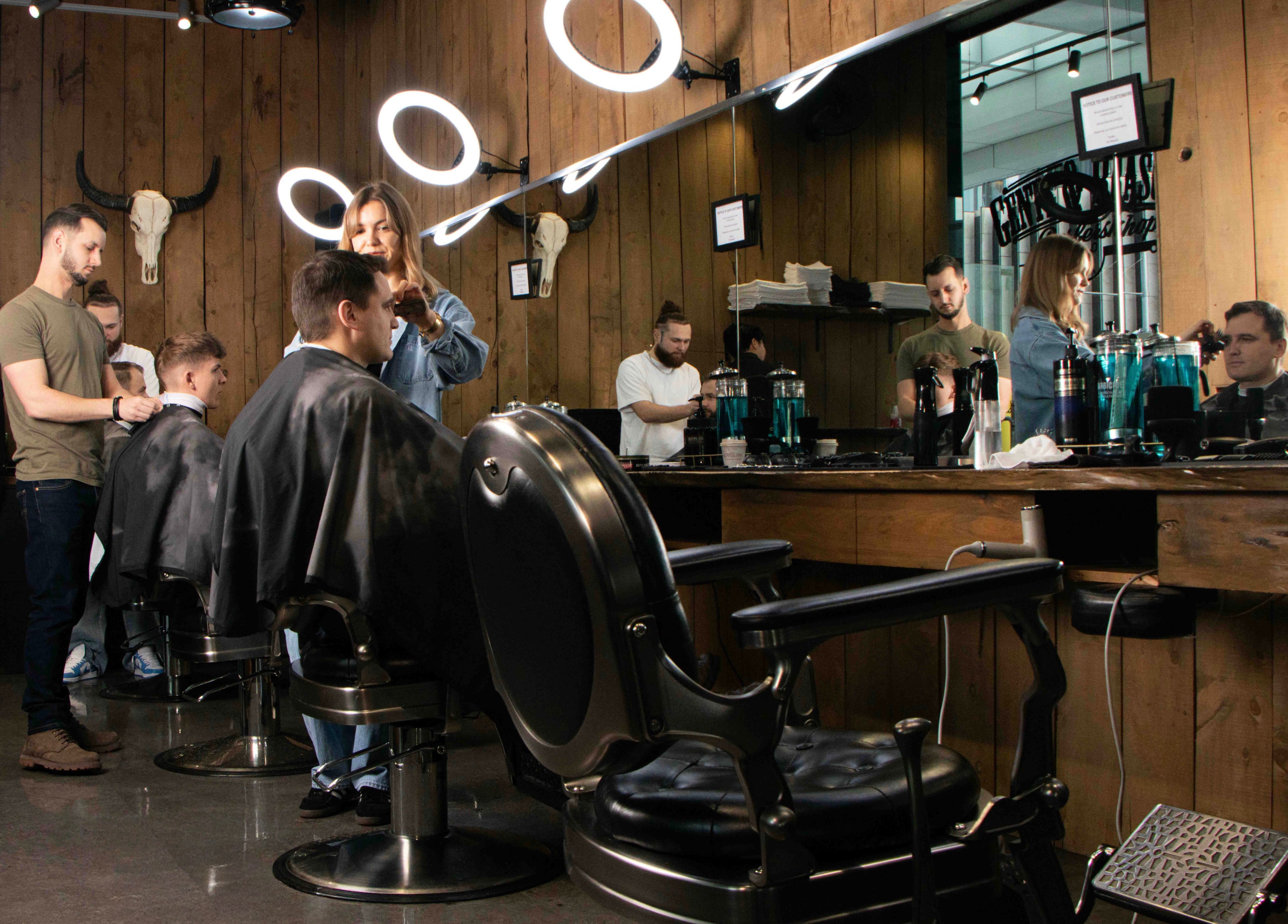 Modern barbershop interior at Gents & Rascals, HSBC tower, Auckland, NZ with customers receiving haircuts.
