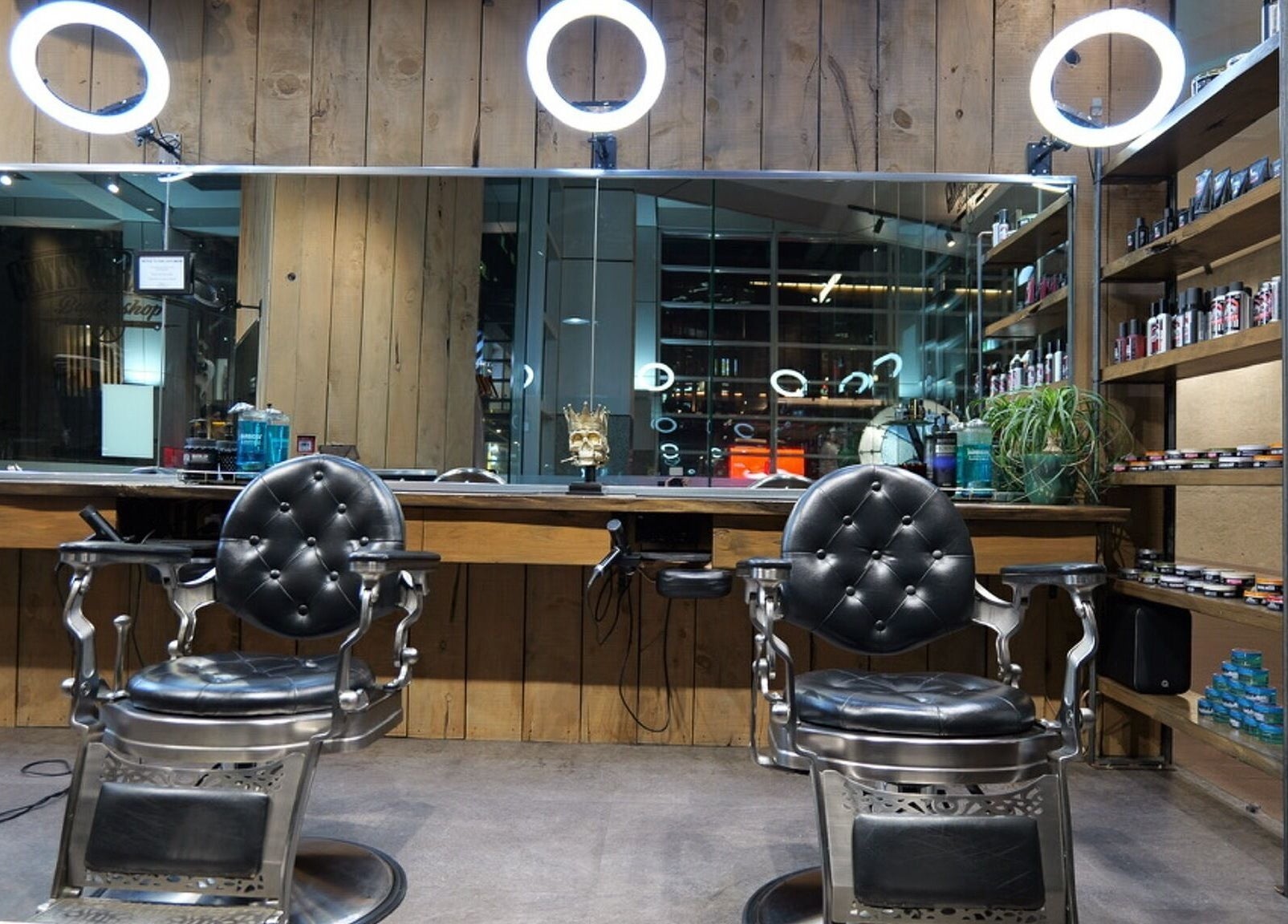 Stylish interior of Gents & Rascals barbershop, HSBC tower, Auckland, NZ with modern chairs and products.