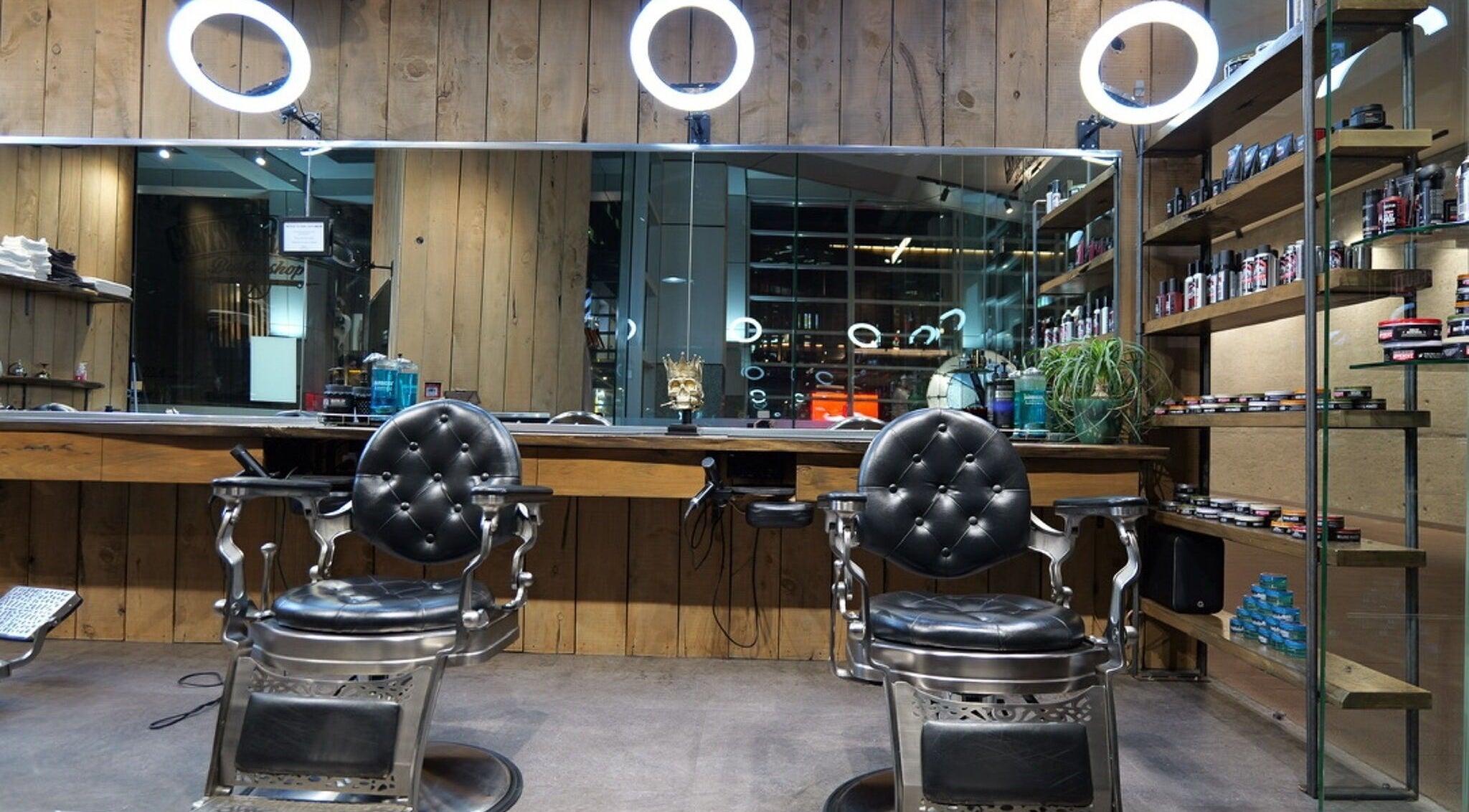 Stylish interior of Gents & Rascals barbershop, HSBC tower, Auckland, NZ with modern chairs and products.