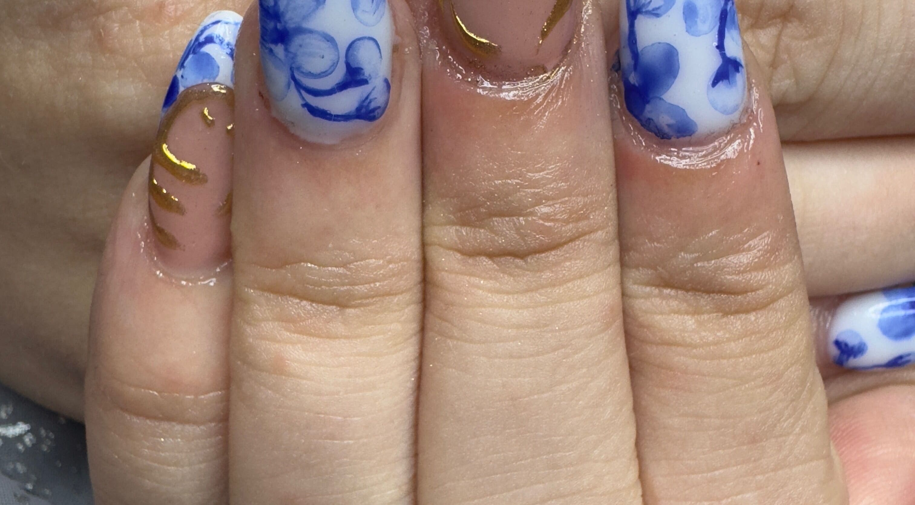 Elegant blue and gold hand-painted nails at WyldNails, Bilsthorpe, England, GB.