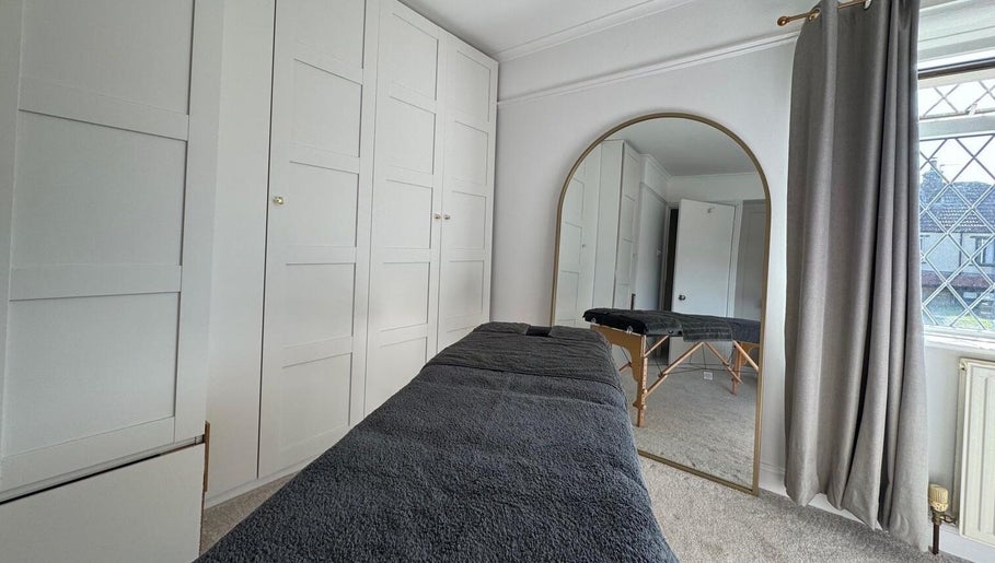 A serene therapy room at SGM Sports Therapy Ltd, East Morton, England, GB, with a massage table and large mirror.