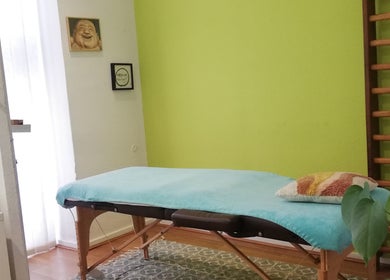 Salle de massage paisible à Massage Taoïste, Lyon, Auvergne-rhône-alpes, FR avec murs verts et table accueillante.