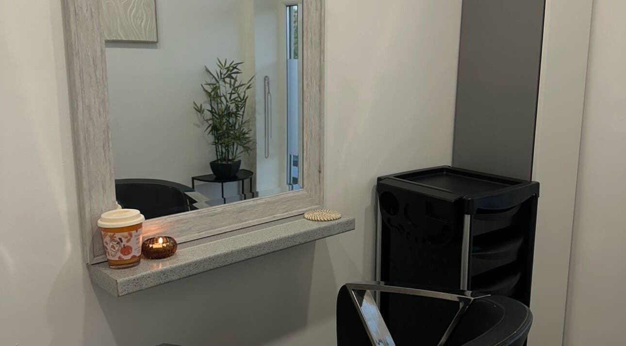 Cozy salon corner at Hair By Rubes, Swinton, England, GB, featuring a stylish mirror and plant decor.