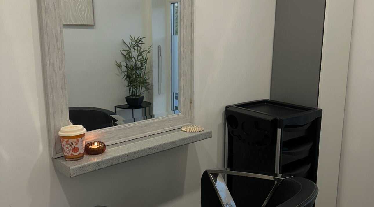 Cozy salon corner at Hair By Rubes, Swinton, England, GB, featuring a stylish mirror and plant decor.