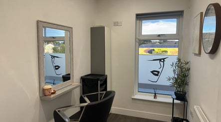 Elegant salon corner at Hair By Rubes in Swinton, England, GB featuring stylish chair and large wall mirror.