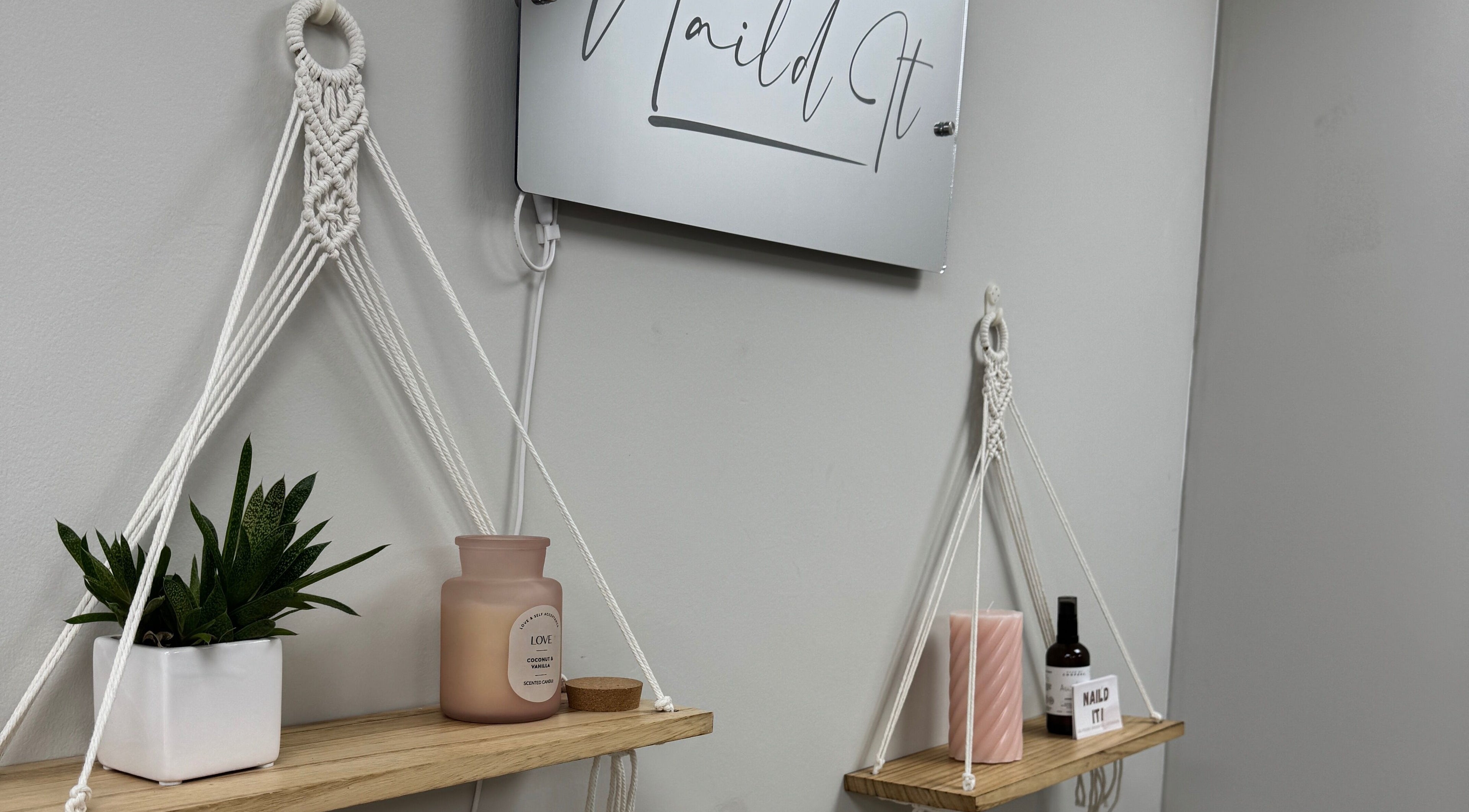 Elegant wall display at Nail’d it!, Yeovil, England, GB featuring hanging shelves and decorative items.