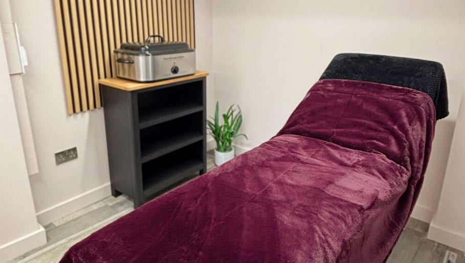 Cozy treatment room at Charley_thedollshouse, Hessle, England, GB with plush burgundy bed.