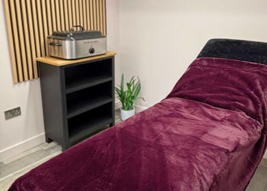 Cozy treatment room at Charley_thedollshouse, Hessle, England, GB with plush burgundy bed.