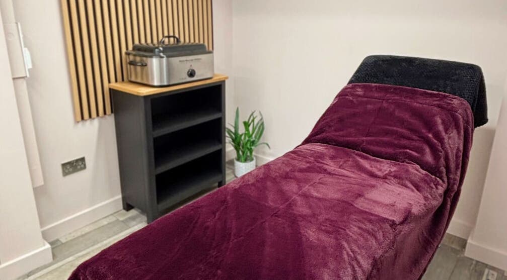 Cozy treatment room at Charley_thedollshouse, Hessle, England, GB with plush burgundy bed.