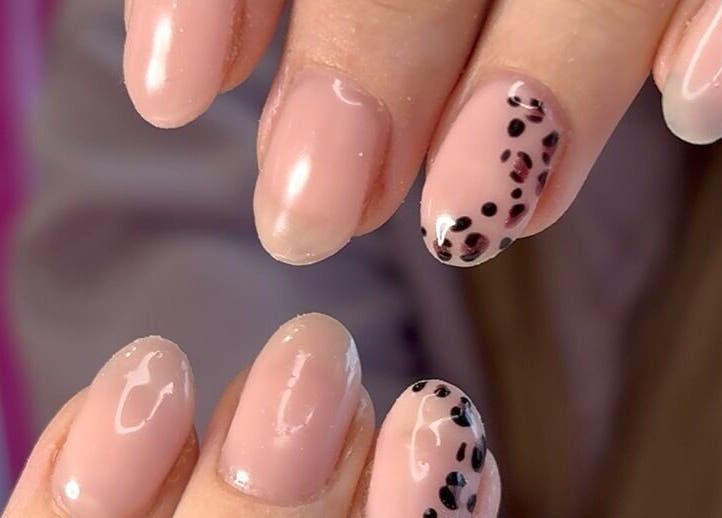 Elegant pink nails with black spots by Niche Nails, Ellesmere Port, England, GB showcasing delicate style.