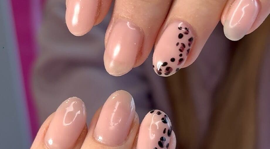 Elegant pink nails with black spots by Niche Nails, Ellesmere Port, England, GB showcasing delicate style.