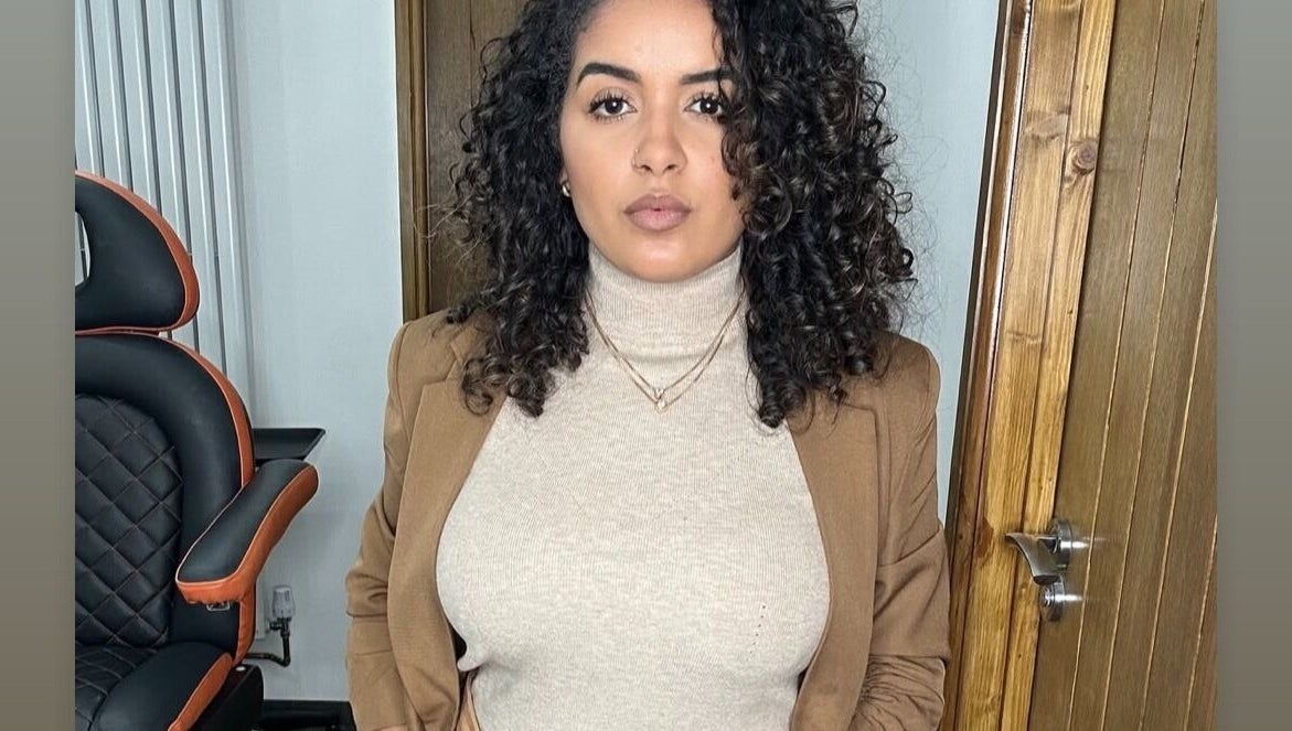 Woman with curly hair in Jessi Porphyrio hair salon, Smethwick, England, GB, showcasing chic interior.