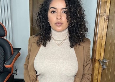 Woman with curly hair in Jessi Porphyrio hair salon, Smethwick, England, GB, showcasing chic interior.