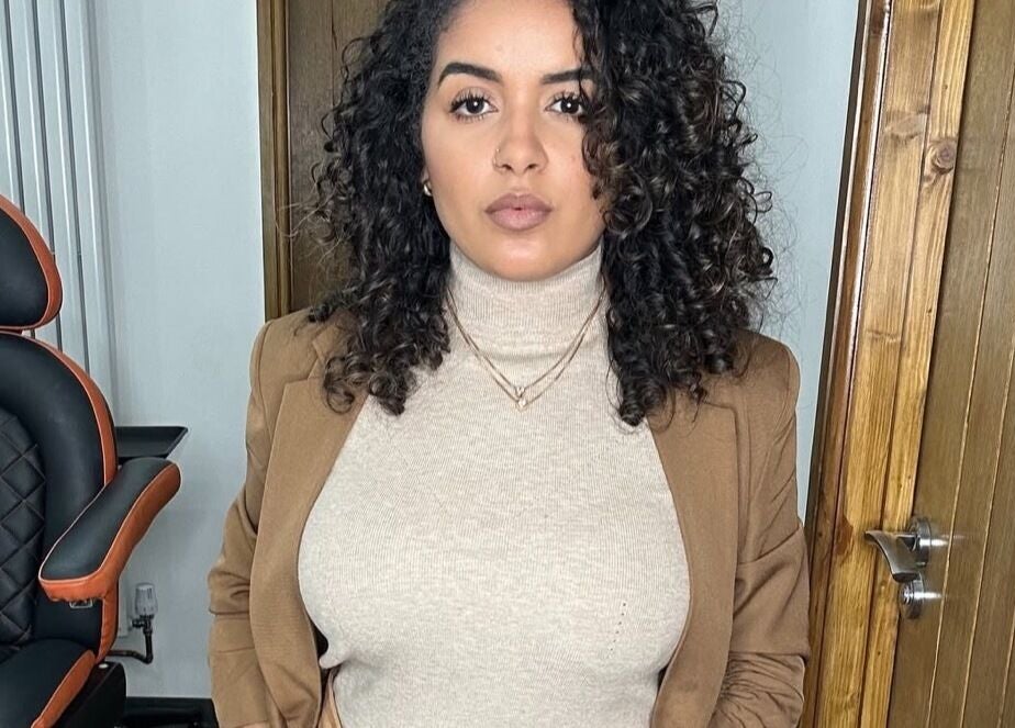 Woman with curly hair in Jessi Porphyrio hair salon, Smethwick, England, GB, showcasing chic interior.