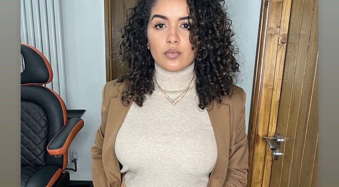 Woman with curly hair in Jessi Porphyrio hair salon, Smethwick, England, GB, showcasing chic interior.