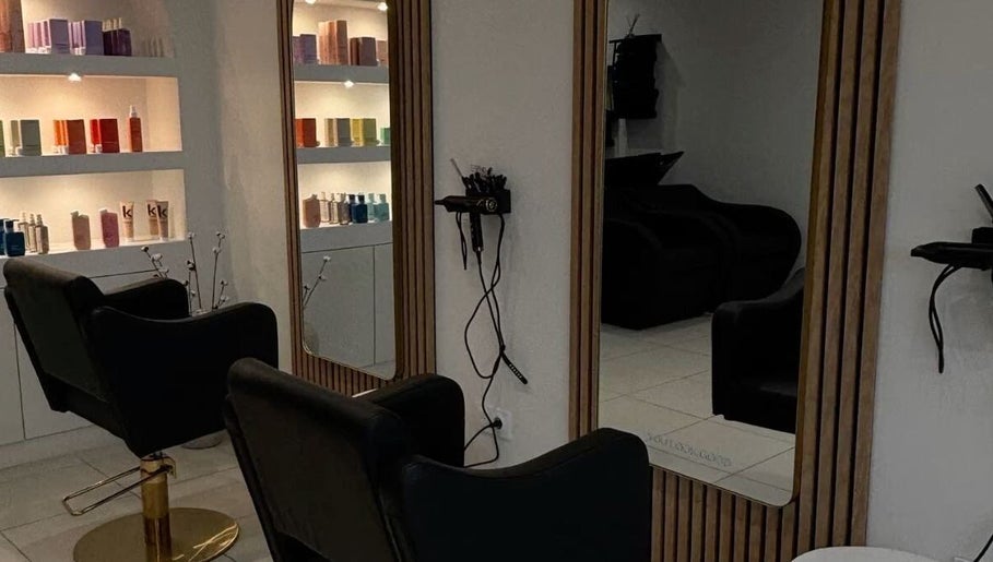 Intérieur élégant de Maison Afro à Toulouse, Occitanie, FR avec fauteuils noirs et étagères de produits.