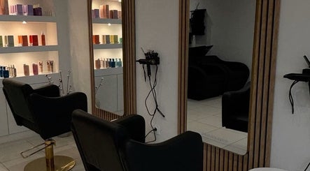 Intérieur élégant de Maison Afro à Toulouse, Occitanie, FR avec fauteuils noirs et étagères de produits.