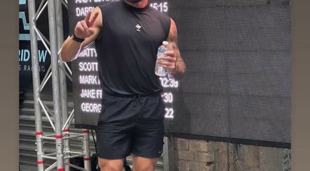 Athlete celebrates after fitness event at RakeFIIT, Cardiff, Wales, GB with peace sign and water bottle.