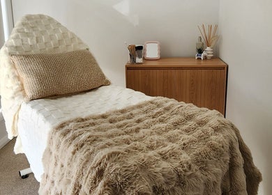 Cozy treatment room at Aurèla Beauty, Austral, New South Wales, AU, featuring a plush treatment bed.