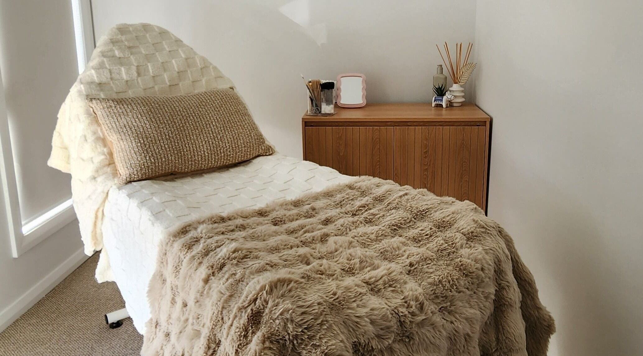 Cozy treatment room at Aurèla Beauty, Austral, New South Wales, AU, featuring a plush treatment bed.